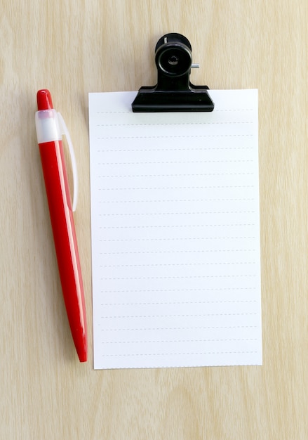 Photo note paper and red pen placed on wooden floor.