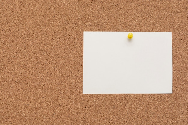 Photo note paper with push pin on cork board