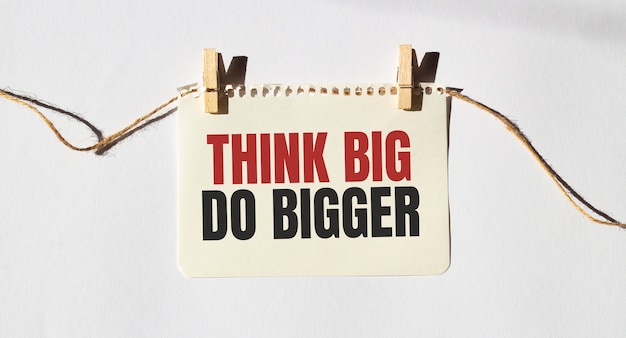 テキスト付きのメモTHINKBIG DOBIGGER。