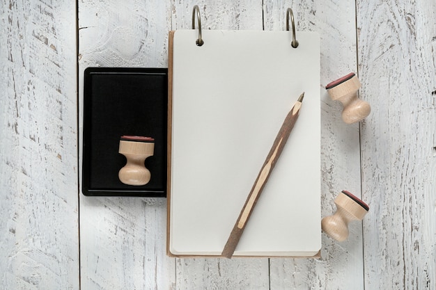 Notebook ambachtelijke papier Kladblok met houten stempel en houten pen op een witte shabby achtergrond. Lege lege Kladblok