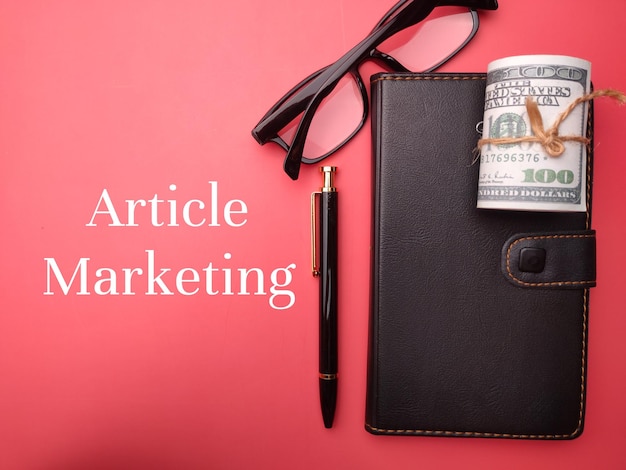 Notebook and banknotes with the word Article Marketing