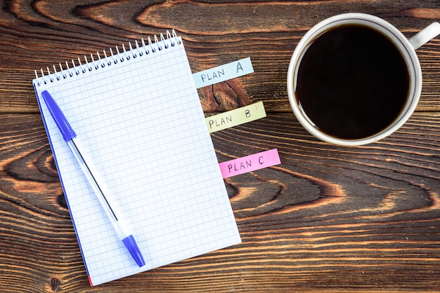 Notebook beside cup of coffee