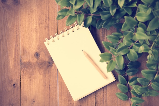 Notebook and brown pencil on wooden table