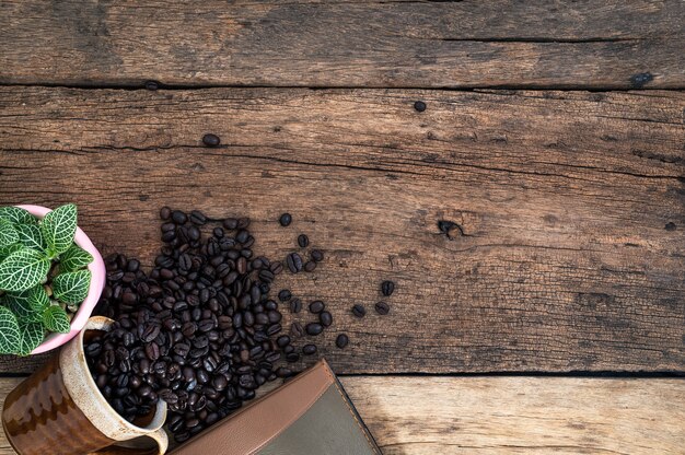 Notebook and coffee beans are placed on the desk top view