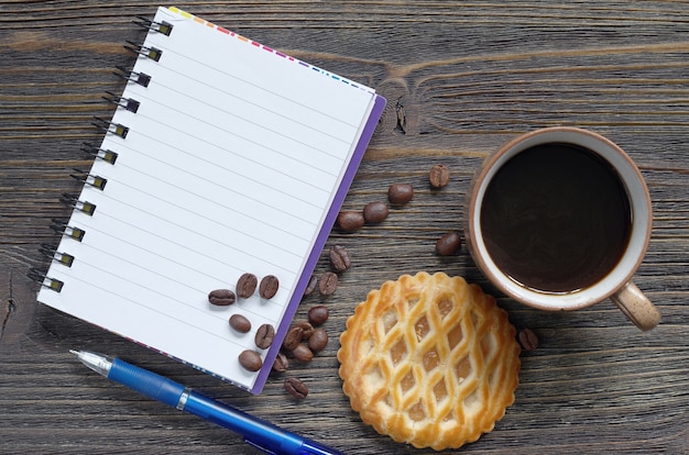 Notebook, coffee and cakes with apple filling