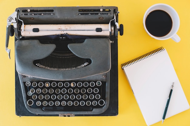 Notebook and coffee near typewriter