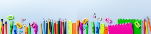 Блокнот, цветные карандаши, линейка, ручка, ластик, точилка и многое другое. Канцелярские товары школы и офиса на синем