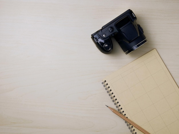 Notebook en camera op houten bureau