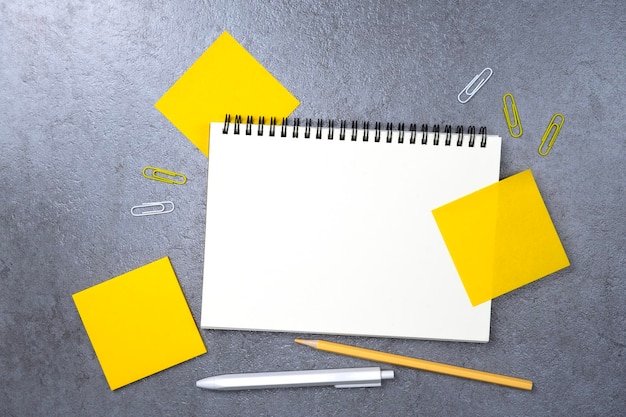 Notebook en gele kleverige notitie op stenen achtergrond Werktafelruimte