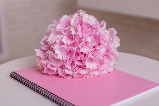 Notebook en hortensia met kopie ruimte op roze achtergrond