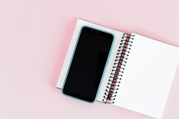 Notebook en smartphone op roze achtergrond Mock up