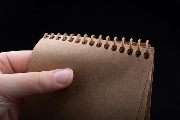 Notebook in hand on a black color background