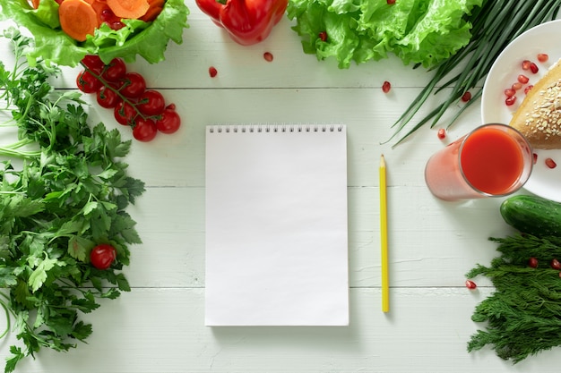 野菜の背景に減量の日記をつけるためのノート。個別の食事療法を作成します。