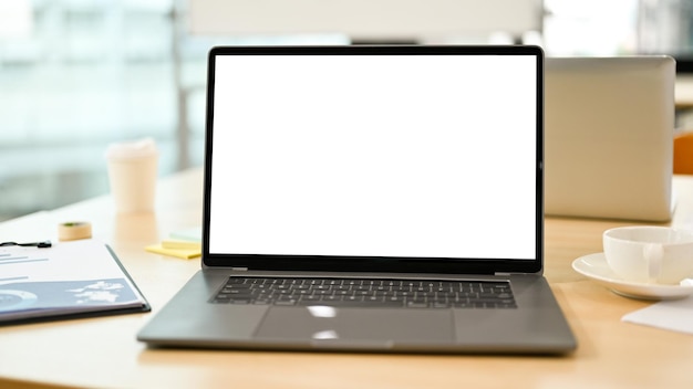 Notebook laptop computer white screen mockup on meeting table closeup image