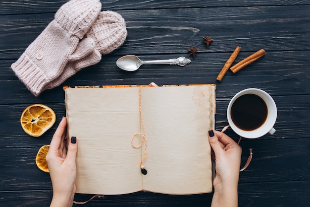 Notebook of memories and coffee on wooden vintage table.