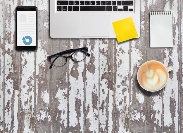 Notebook and mobile phone and paper of note on working desk