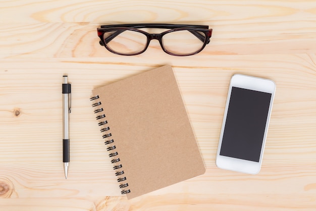 Notebook and mobile phone on wood background