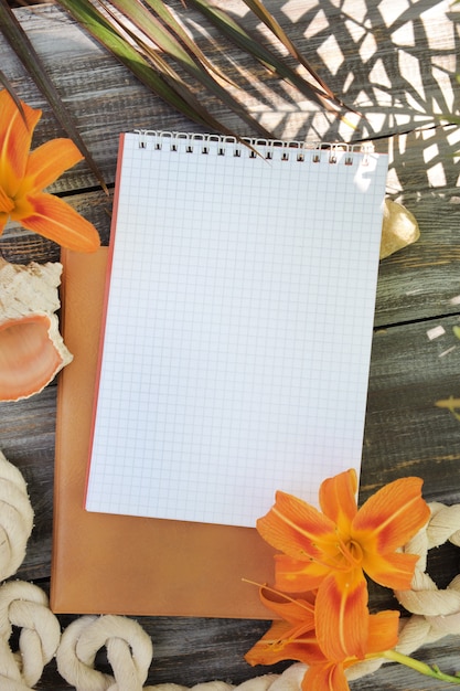 Notebook mock-up met leliebloemen, buiten zomerfoto