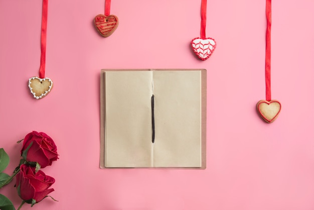 Notebook op roze achtergrond werkplek op Valentijnsdag