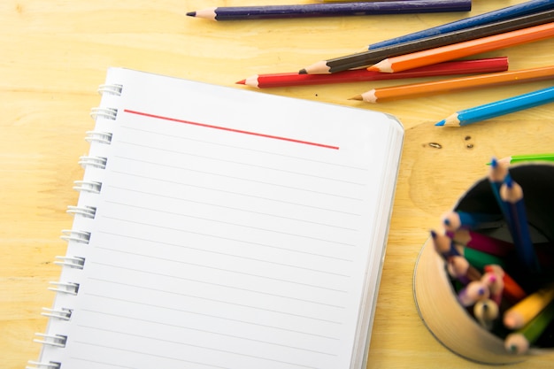 notebook paper and color pencil on wooden table. Back to school.