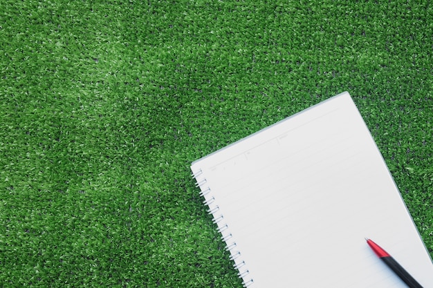 notebook and pen on artificial grass