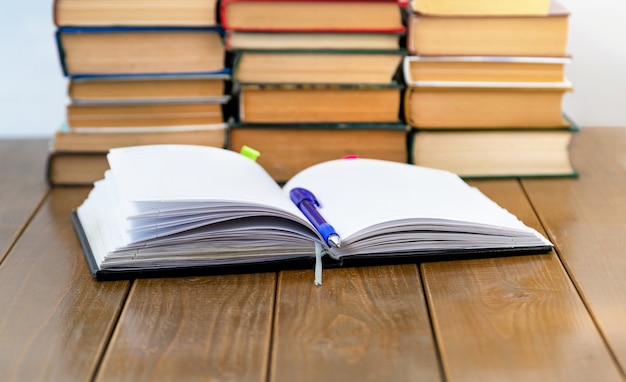 Notebook pen and books on the table Closeup