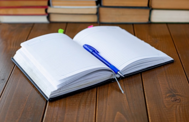 Notebook pen and books on the table Closeup