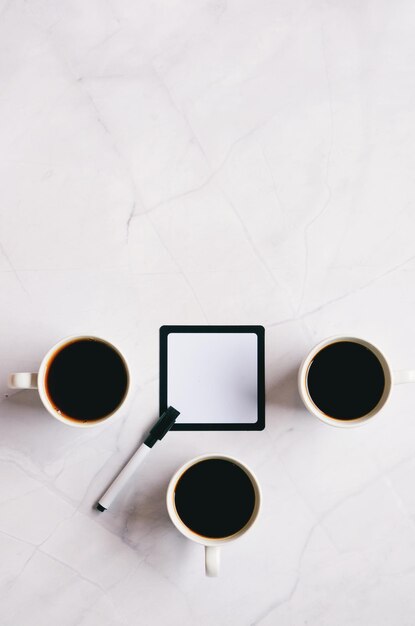 notebook, pen, kop warme koffie en zoete croissant op witte achtergrond. Bovenaanzicht, kopieer ruimte