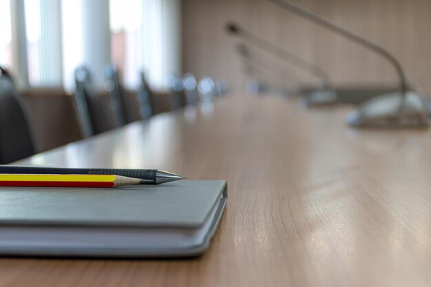 Notebook pen and pencil on table in meeting room