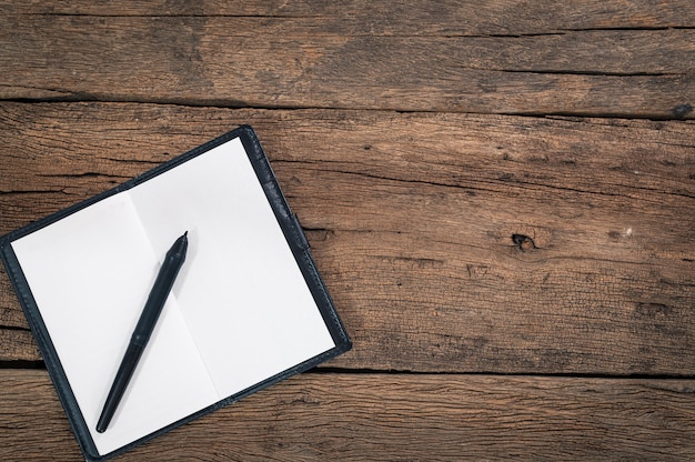 A notebook and a pen on the table top view