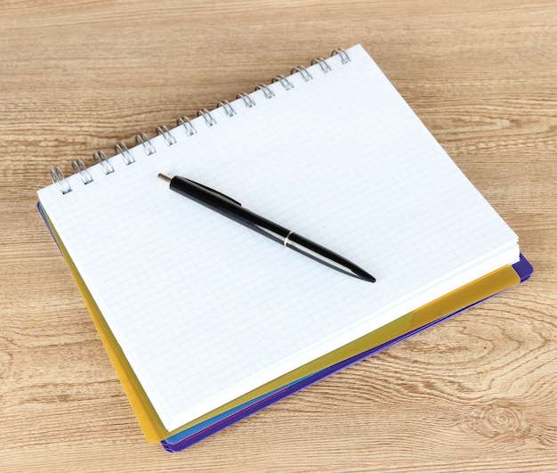 Notebook and pen on wooden table