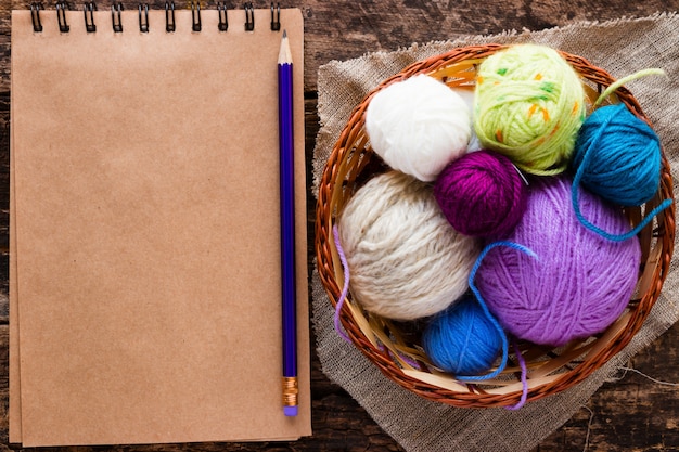 Photo notebook, a pencil and a basket with balls  yarn