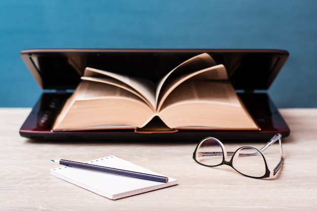 Notebook, pencil and glasses on a desk