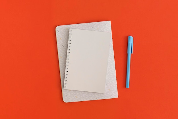 Notebook and pencil on red background Top view Flat lay Back to school concept