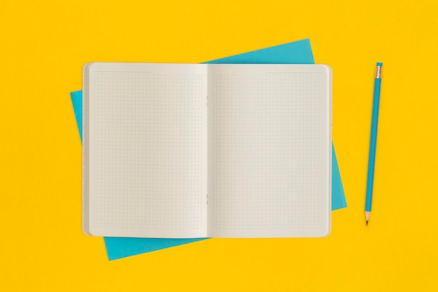 Notebook and pencil on yellow background Top view Flat lay Back to school concept