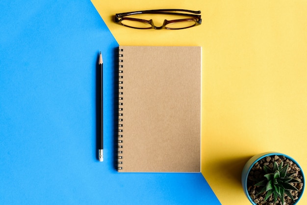 notebook and pencil on yellow desk