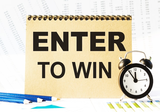 Notebook, pencils and clocks on the table with financial papers. your text ENTER TO WIN