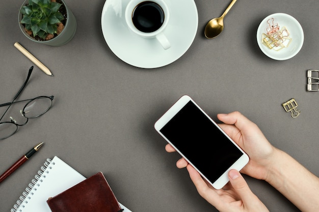 Notebook, planner, bril en vrouw handen met smartphone met zwart scherm