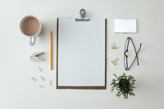 Notebook plat lag op een witte achtergrond met zomerbladeren en ander briefpapier in trendy opstellingsstijl