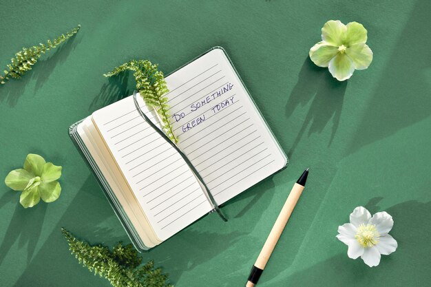 Notebook text Do something green today with lants and flowers Fern leaves green white Helleborus