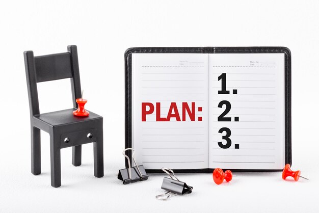 Notebook on white table with text PLAN Businessman's table Planning concept