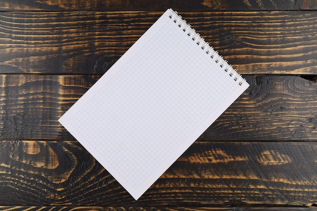 Notebook with cells on a wooden background empty notebook on wooden table top view