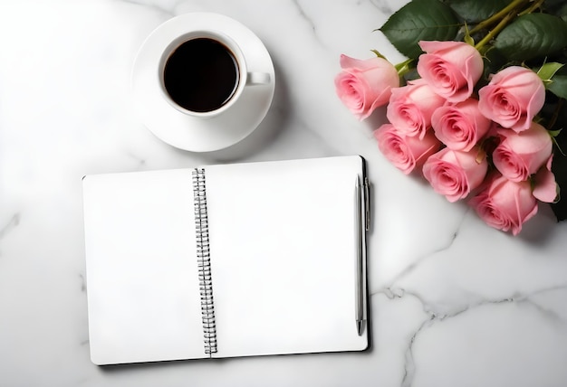 a notebook with a cup of coffee next to a bunch of pink roses