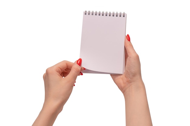 A notebook with empty white paper in woman hands with red nails