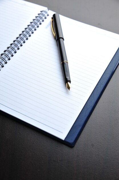 Notebook with fountain pen on wooden table