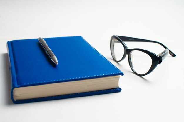 Notebook with glasses and pen, Book with glasses, Blue notebook with glasses, Book with cup of tea