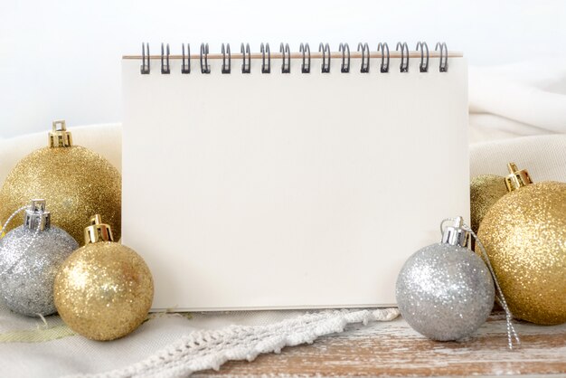 Notebook with Gold and silver Christmas ball on wood table