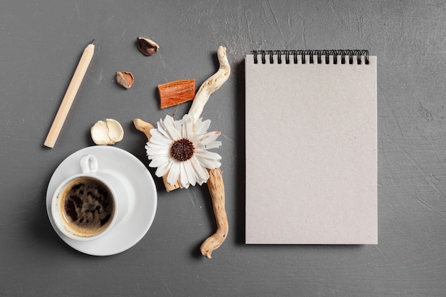 Notebook with pen, coffee and flower on table