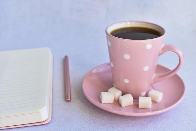 Notebook with pen and a Cup of black coffee on white background business minimal concept for women