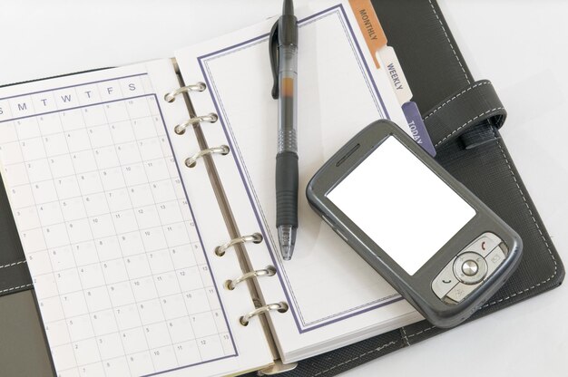 Photo a notebook with a pen and a pen on it next to a notepad